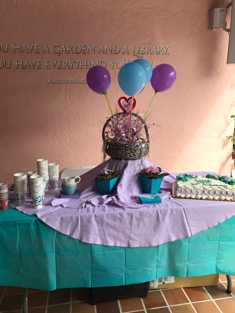 Balloon arrangement sitting on table with cake and cups