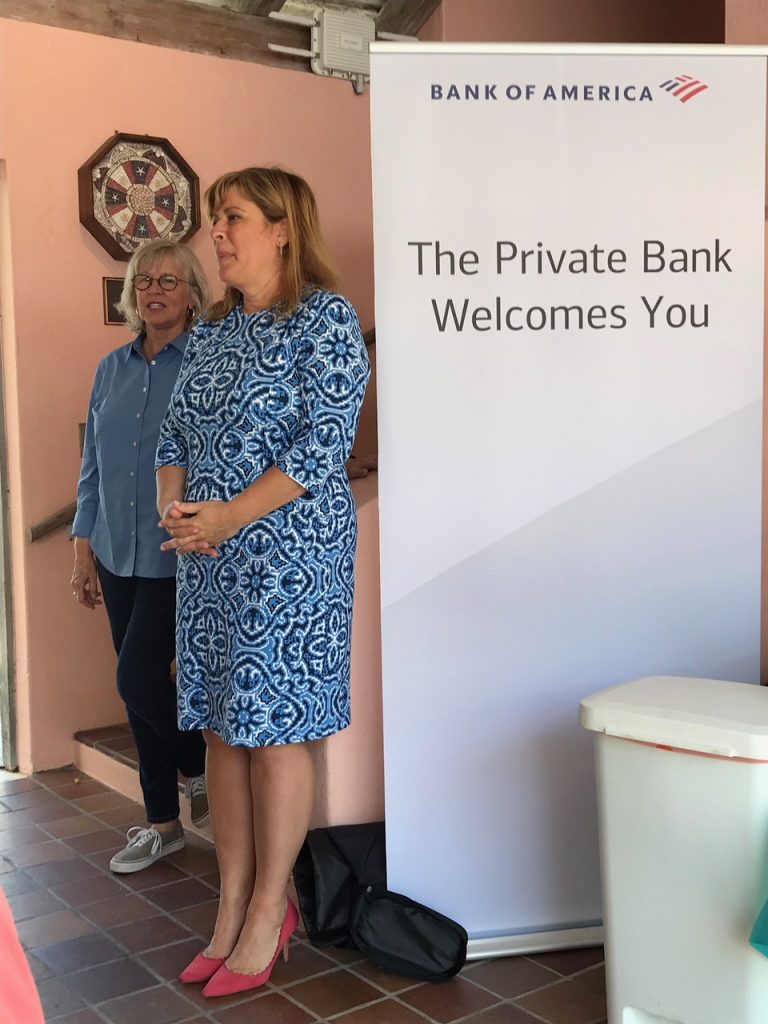 woman standing next to sign of Bank of America - The private bank welcomes you