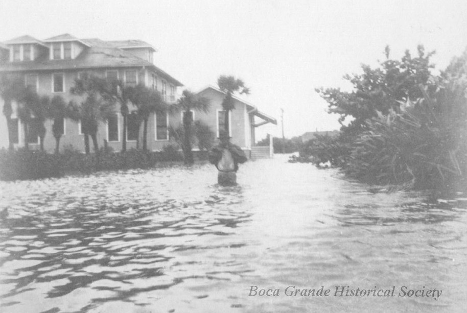 man walking in flood waters up to his hips around the Gasparilla Inn after the 1921 hurricane