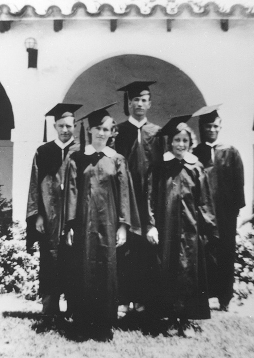 a group of five graduating students wearing caps and gowns