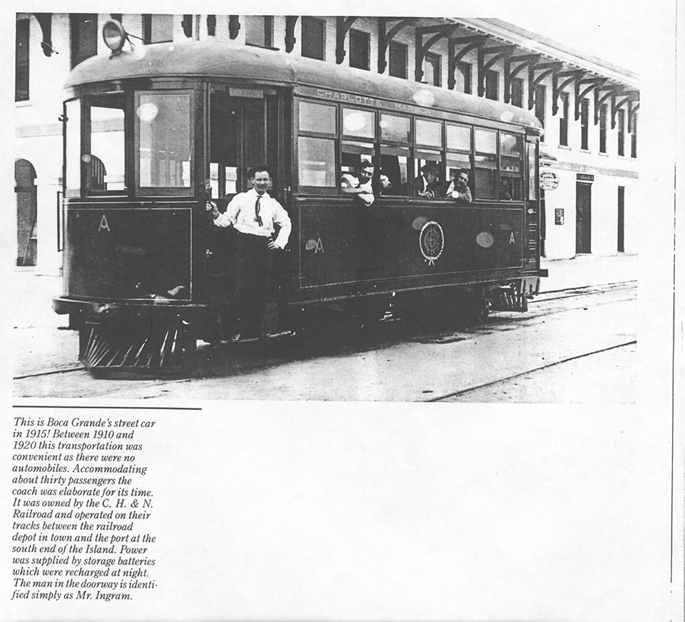 Electric Trolley in front of Railroad Depot with descriptive text: This is Boca Grande's street car in 1915! Between 1910 and 1920 this transportation was convenient as there were no automobiles. Accommodating about thirty passengers the coach was elaborate for its time. It was owned by the C.H. & N. Railroad and operated on their tracks between the railroad depot in town and the port at the south end of the Island. Power was supplied by storage batteries which were recharged at night. The man in the doorway is identified simply as Mr. Ingram.